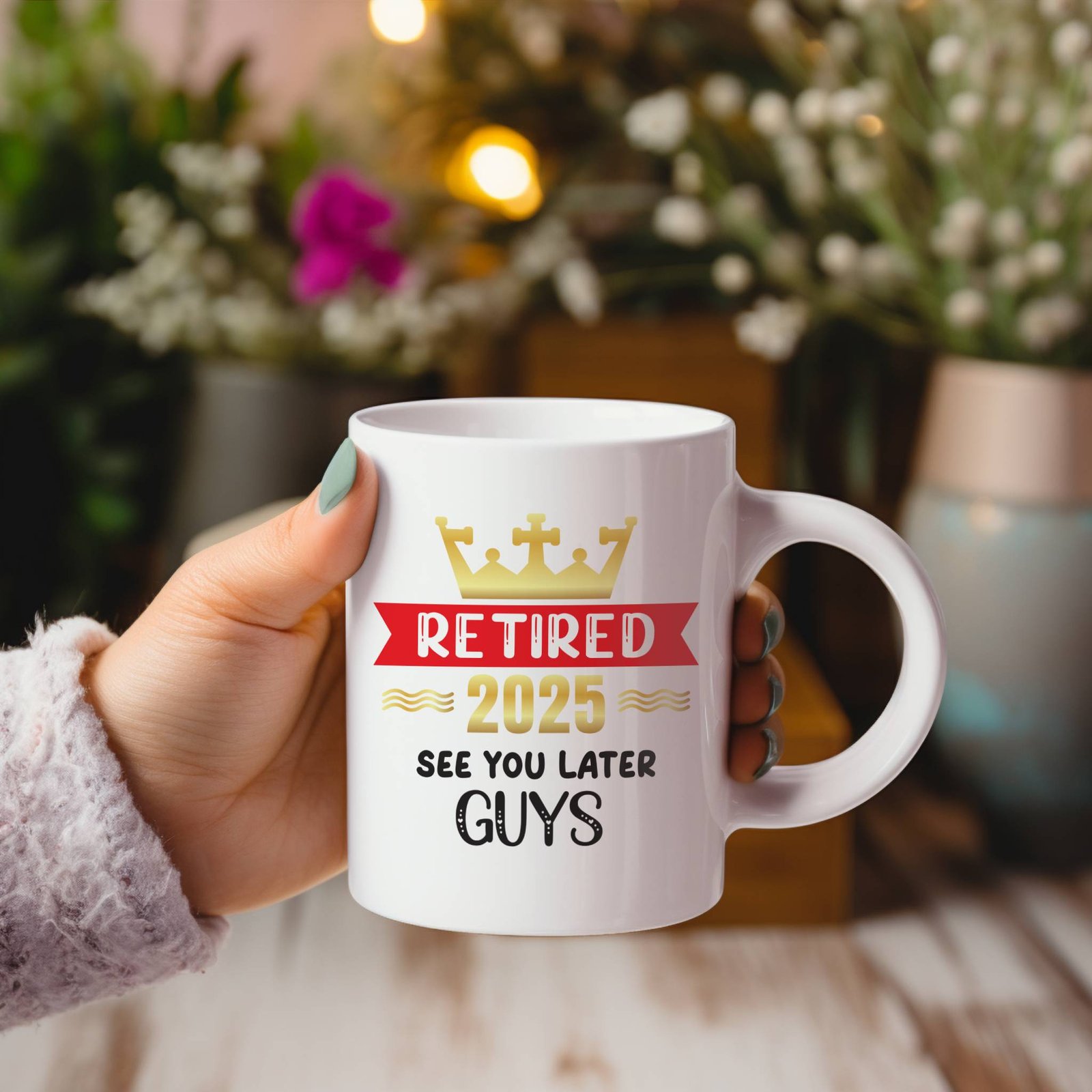 retired 2025 retirement mug gift held in one hand by woman with plants